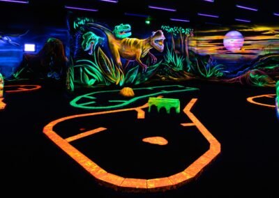 minigolf-loisirs-fluorescent-fluo-activité-fun-blacklight-jouer en famille-activité loisirs montpellier-activité indoor-minigolf fluo-univers-jurassique-décors-fantastique-dinosaures-tyranosaure-t-rex-dino-décors animaux-espèces disparues-